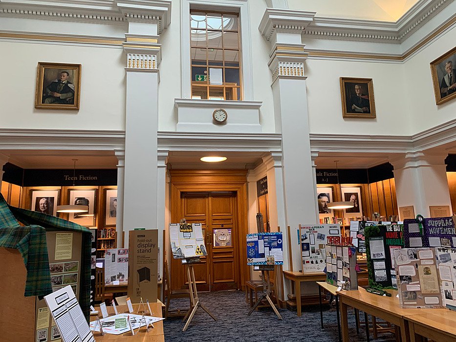 Library with bookshelves, seating areas and historic interior.