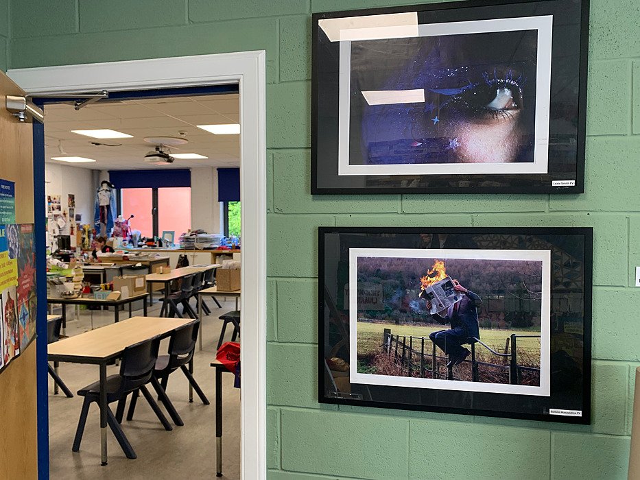View into a modern classroom with group tables and large windows.