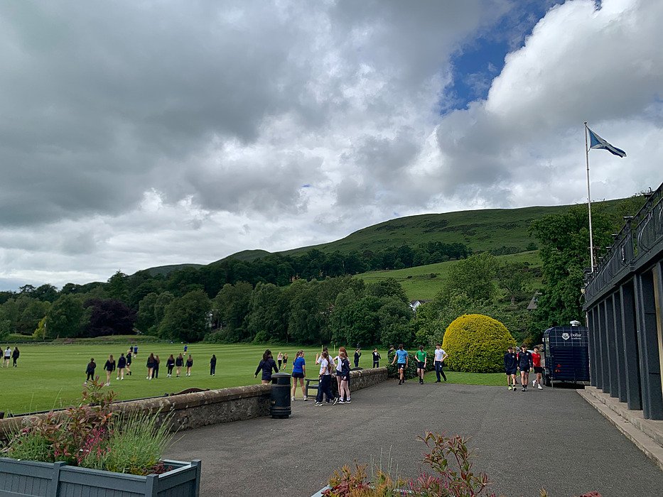 arge campus lawn with the green Ochil Hills in the background.