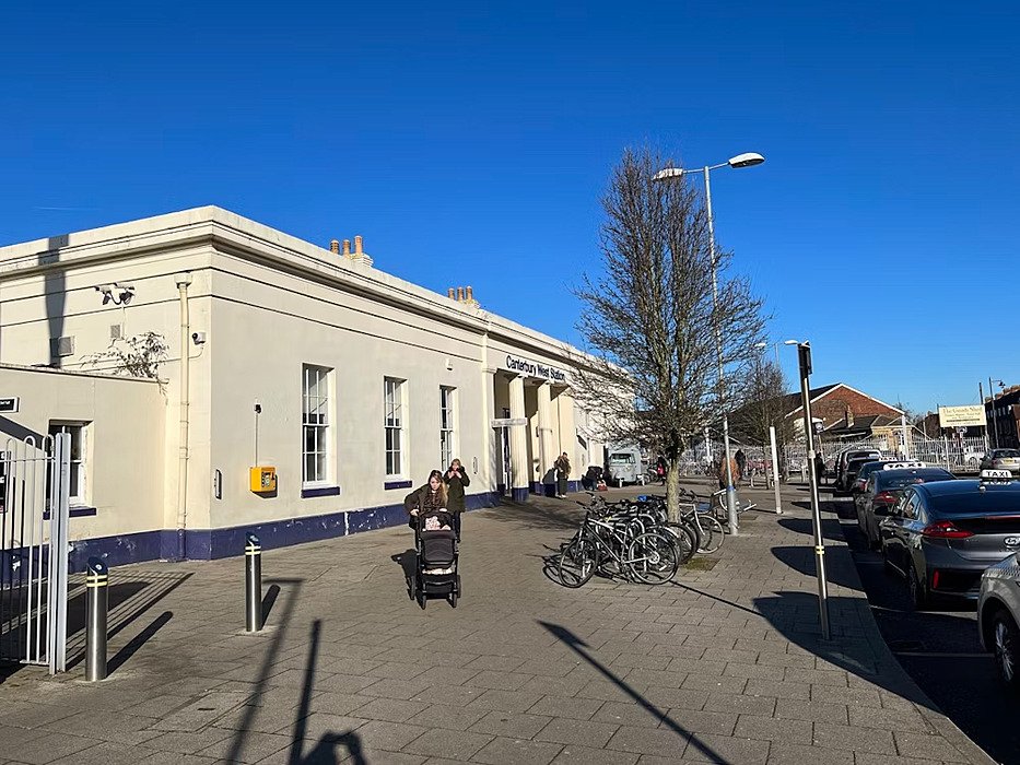 The white station building of the Canterbury West Station with bicycle parking in the front