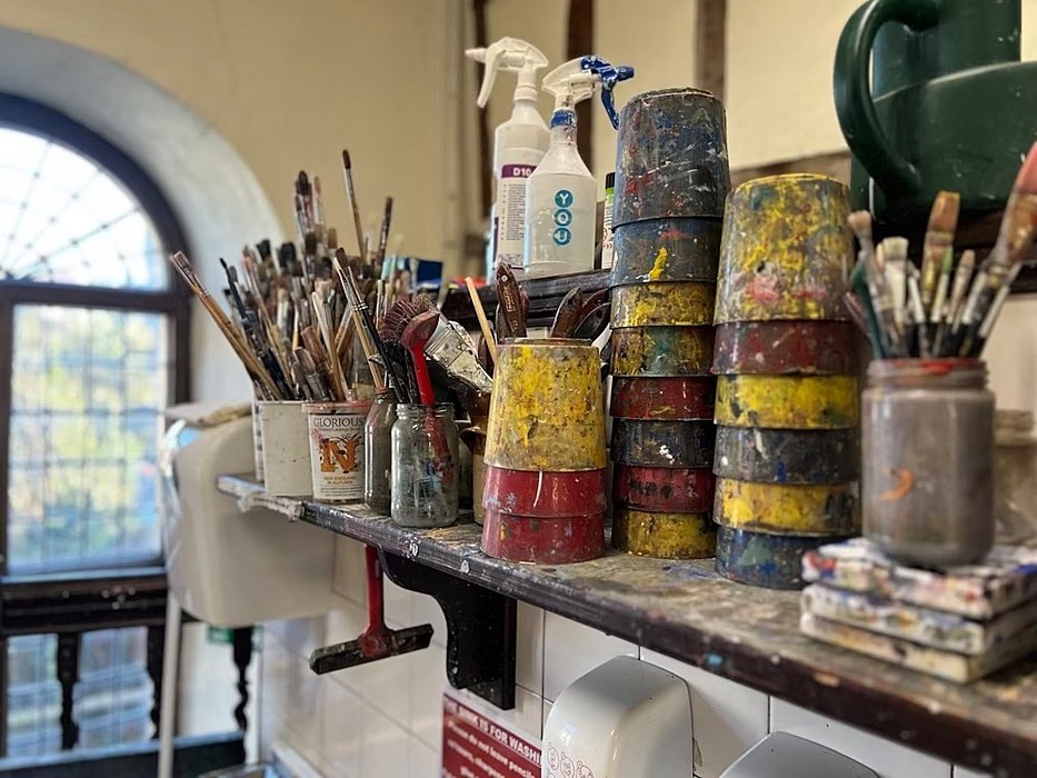 A busy shelf with brushes and arts and crafts equipment at the arts department of King's School Canterbury