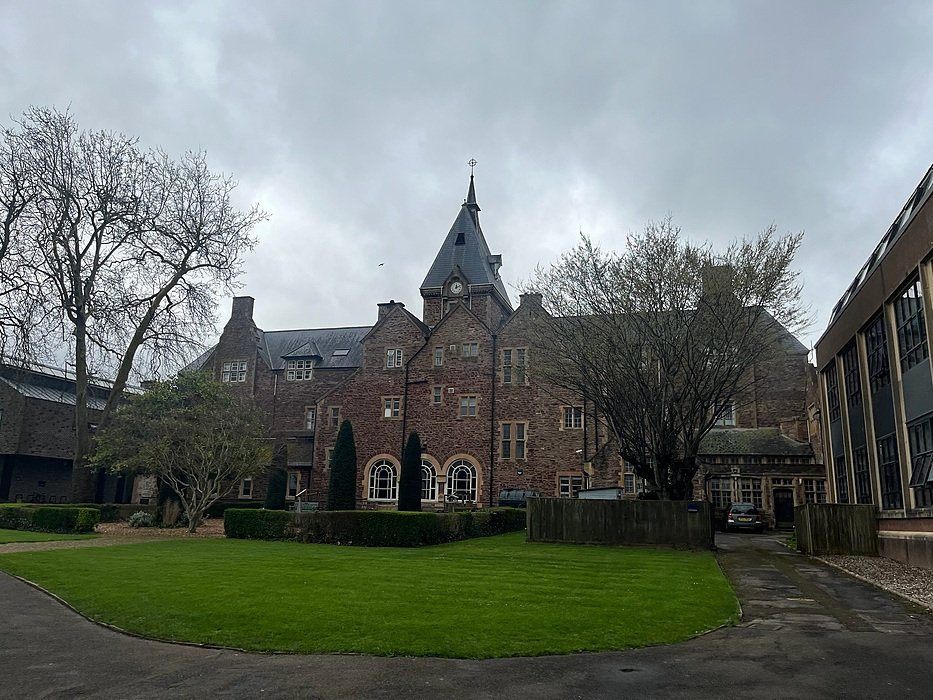 Historic neo-Gothic school building on well-kept campus grounds