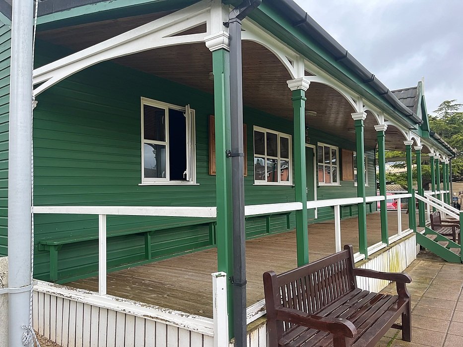 School veranda with wooden bench overlooking campus grounds
