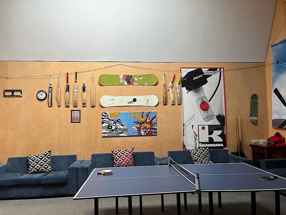 Student lounge with table tennis, sofa and decorative wall art in boarding house