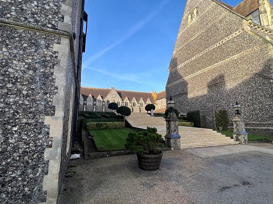 stairs leading up to a big inner courtyard surrounded by beautiful old school buildings