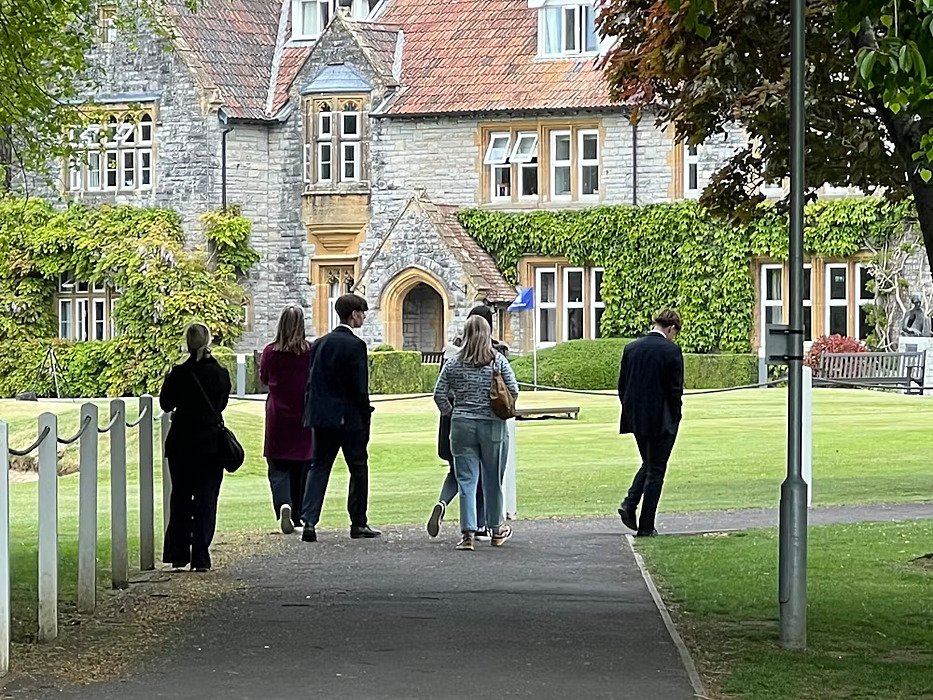 A group of people walking away towards the main house