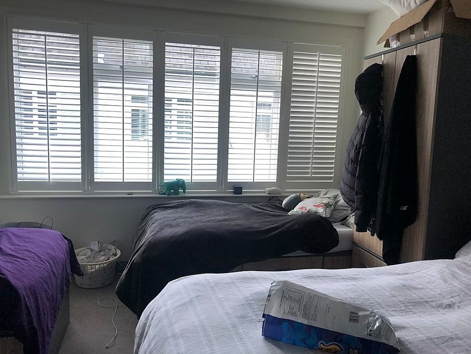 Room with three beds and a wardrobe, a big window