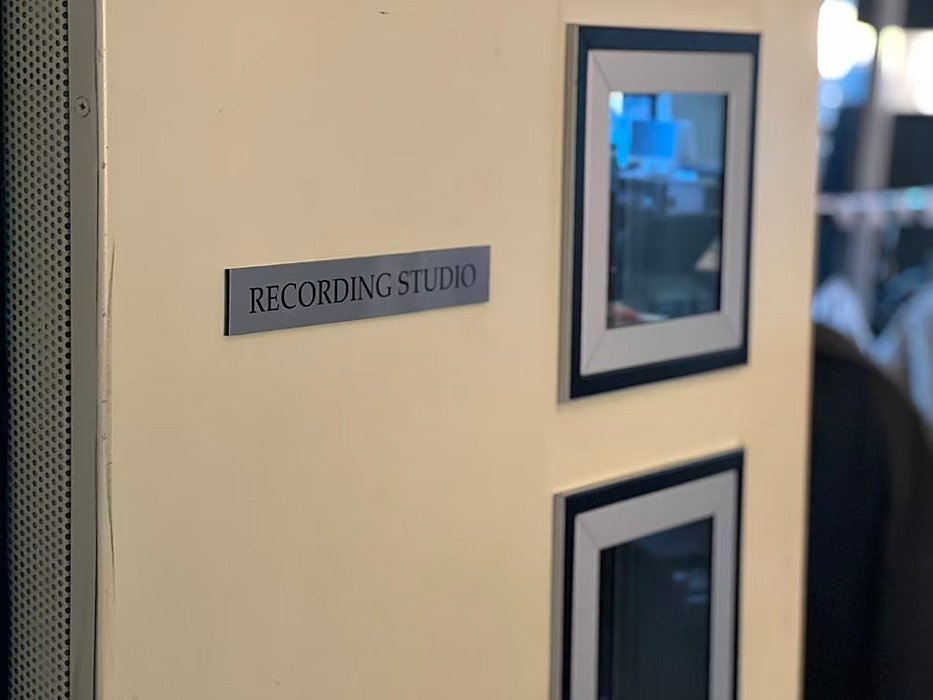 Half open Door with sign that says recording studio