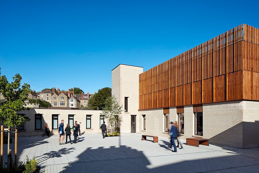 School campus on a sunny day with music building and rushing pupils