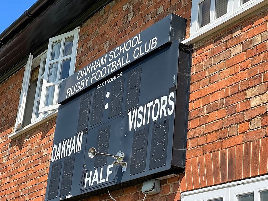 Wall with sports display saying Oakham and visitors