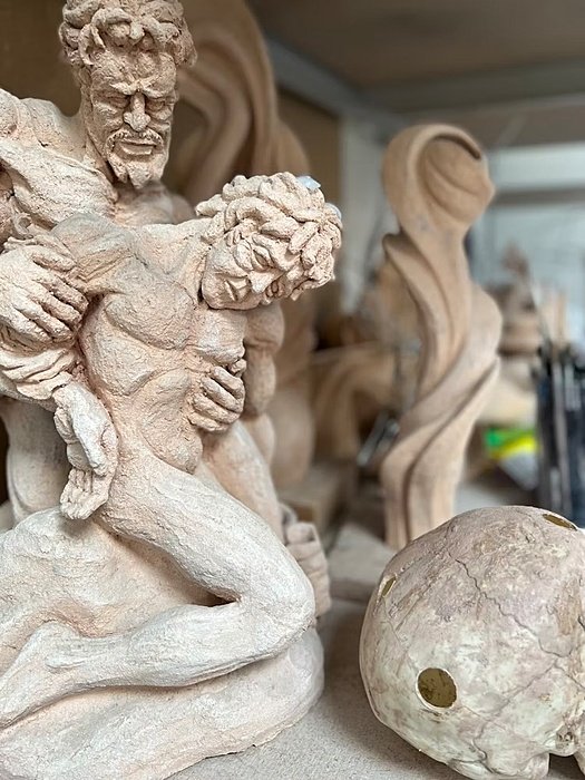Pottery sculpture of a male father holding his dying son