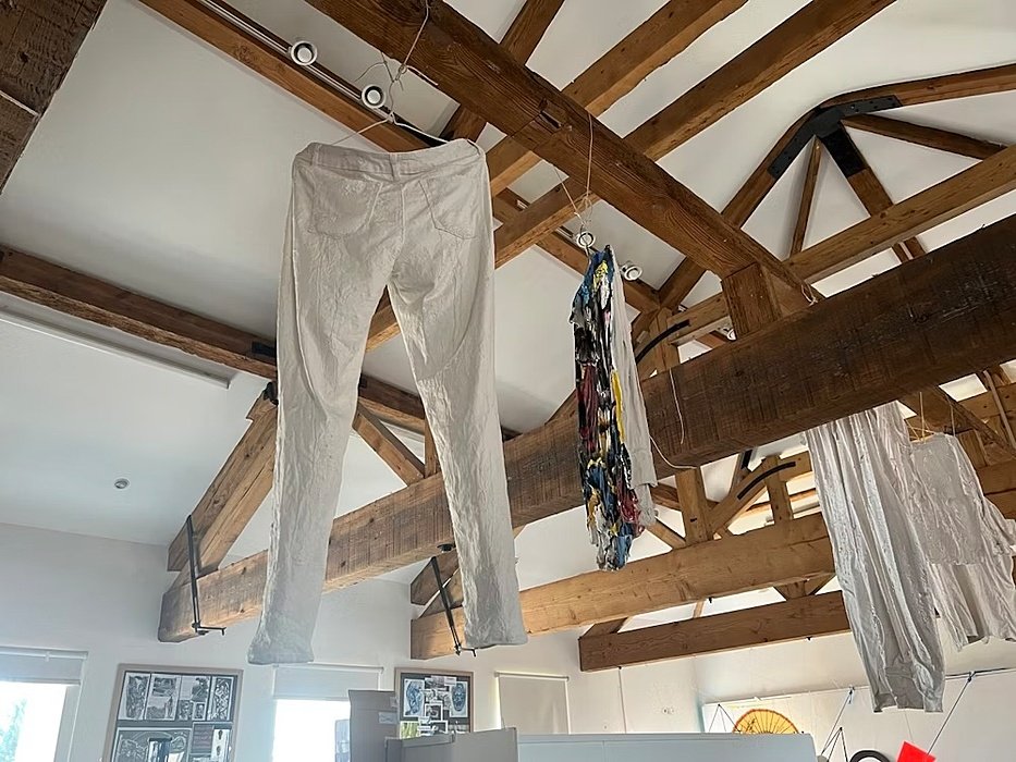 trousers hanging from a ceiling on wooden beams