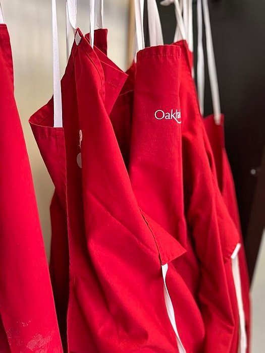 Red aprons with the "Oakham" logo