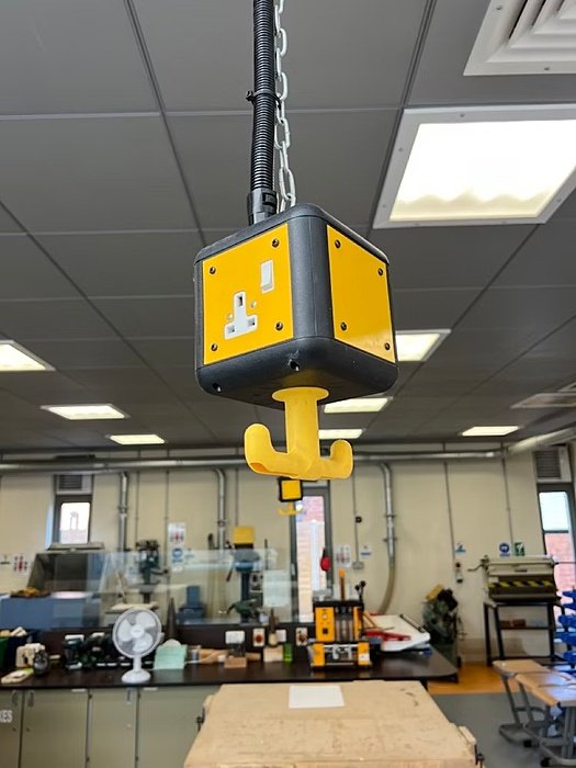 garage full of machines and a yellow crane hanging from the ceiling