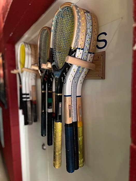 Tidily hung up Real Tennis rackets