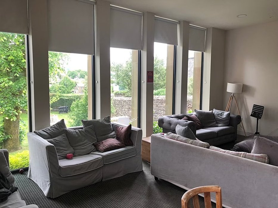 the cosy living room with three sofas and cushions in a boarding house