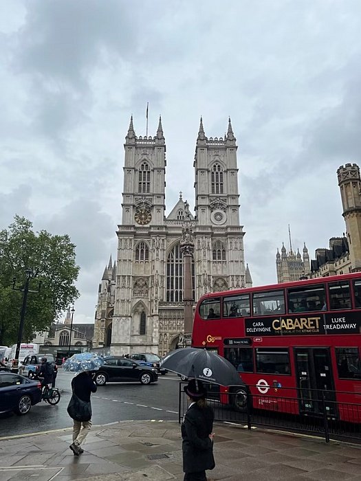 The view of a red doppeldecker bus in front of Westminster Abbey right outside Westminster School