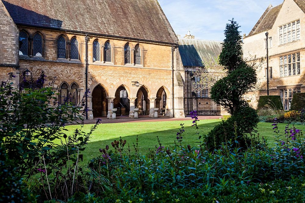 Old school buildings, green and some plants in the front