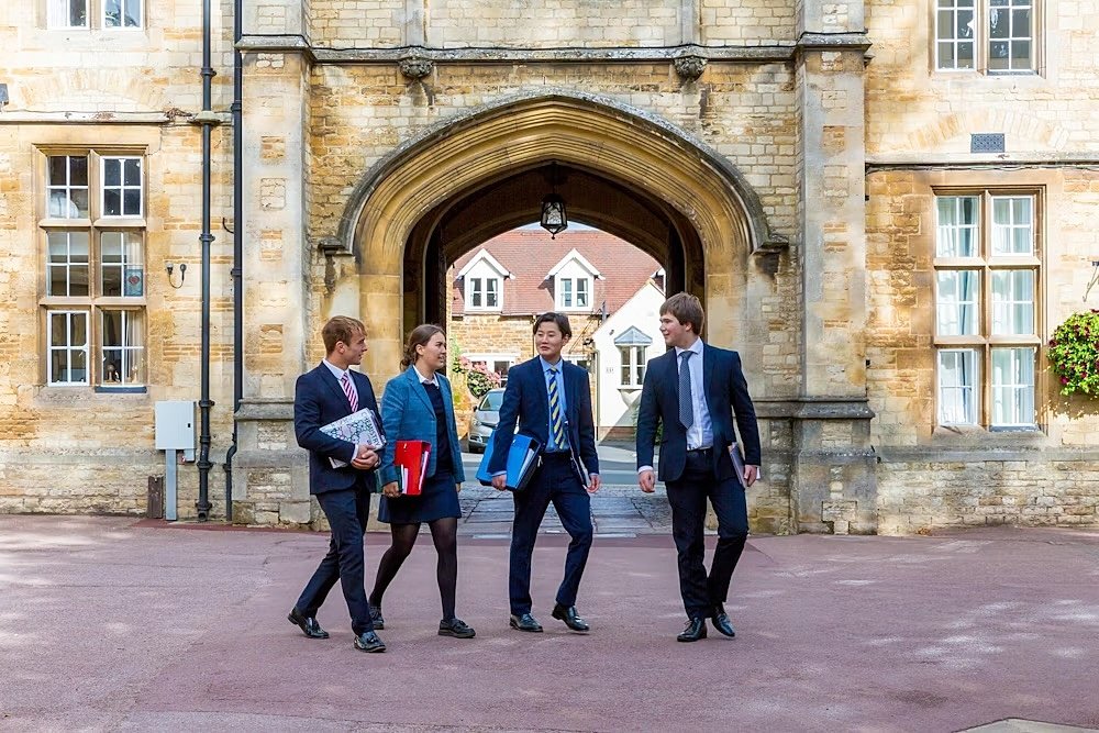 Four pupils in front of an old archway