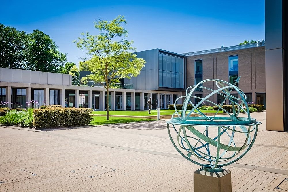 A sun clock infront of modern school buildings