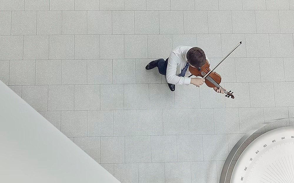 A student playing the violin, seen from above