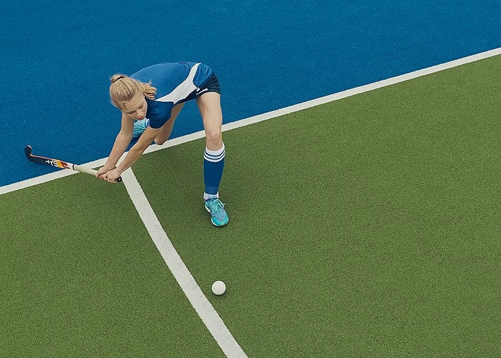 Hockey girl hitting a ball