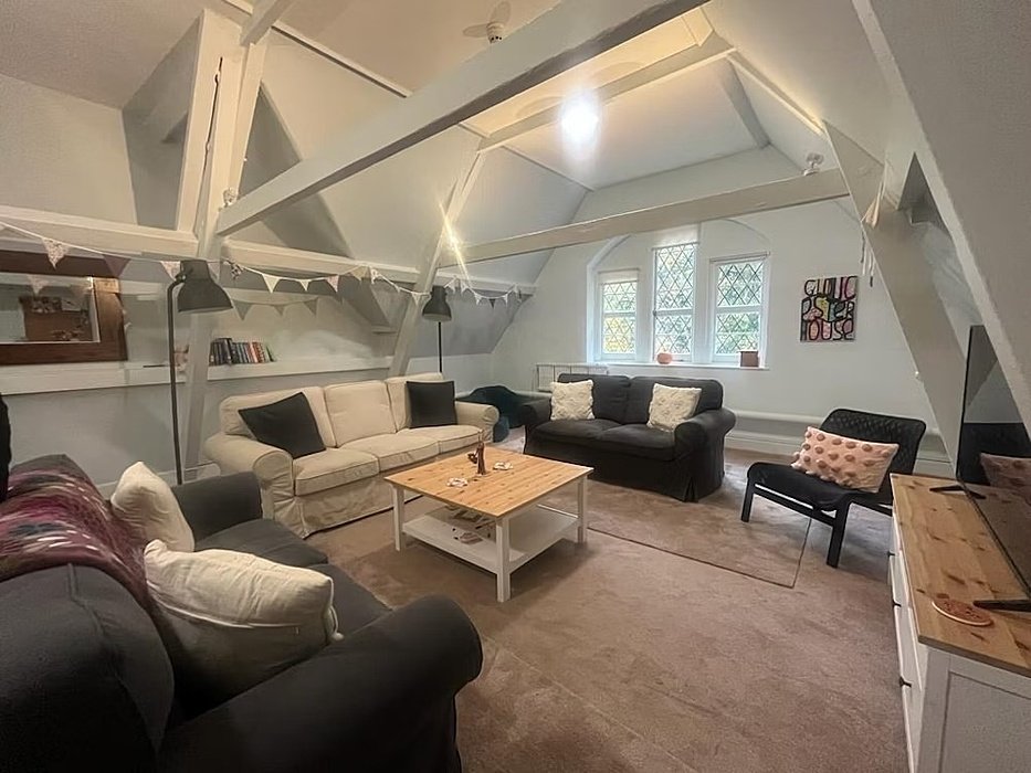 Living room with three sofas, a small table, screen and chair