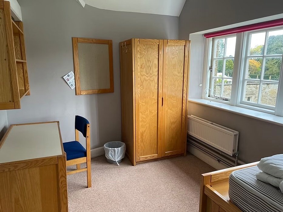 Tidy single bedroom with a wardrobe, desk, chair and bed