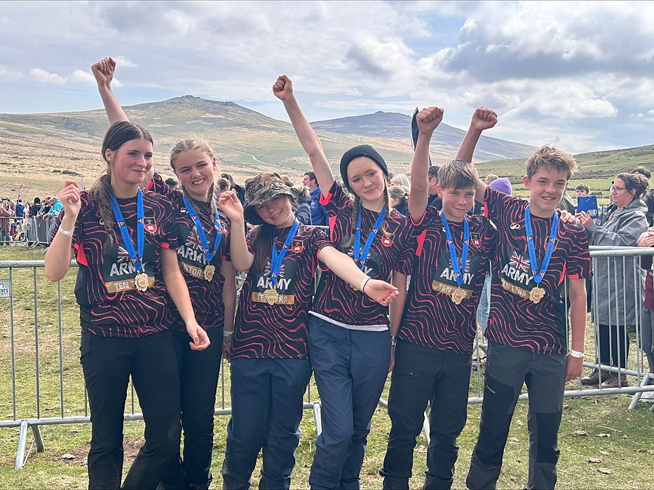 Six pupils wearing gold medals and sticking fists up in celebration