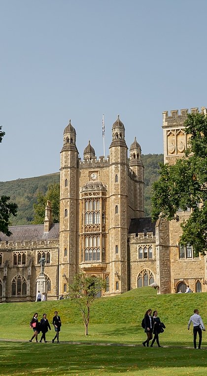 The stunning campus of Malvern College with pupils walking in front in the afternoon