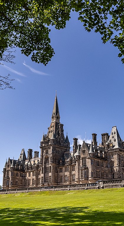 View onto Fettes College framed by green trees