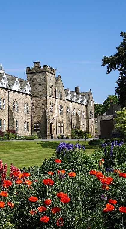 Giggleswick School surrounded by beautiful flower beds and trees on the campus