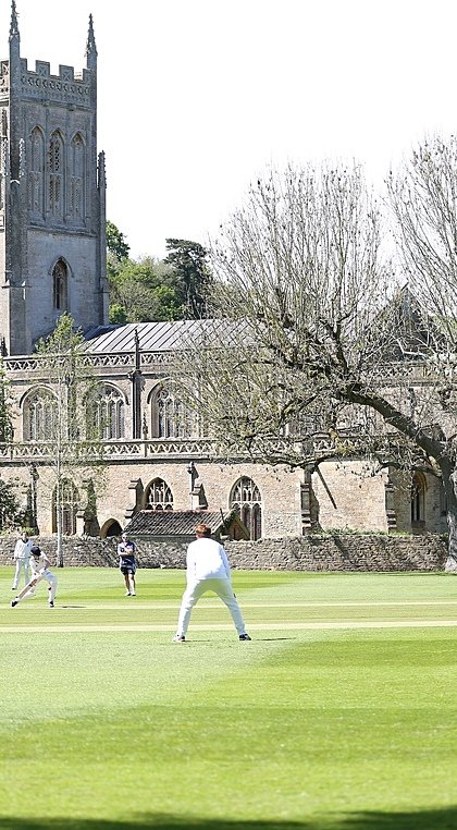 King's Bruton with cricket players on the green in front of the school