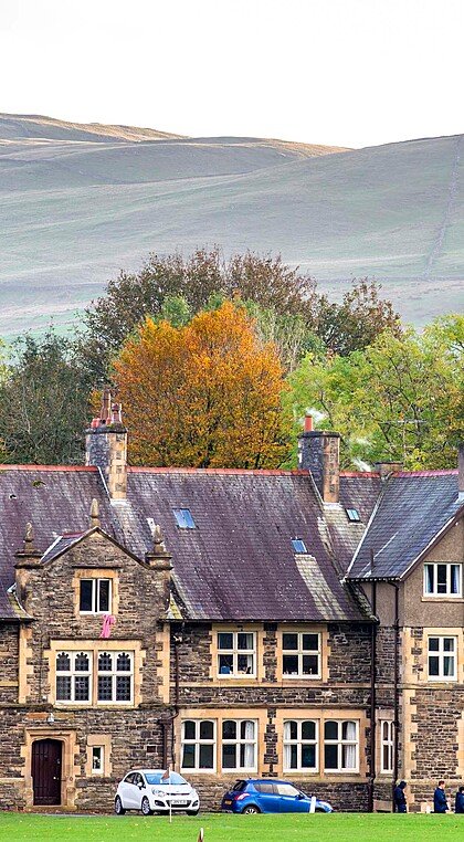 The main building of Sedbergh School in front of a mountain range