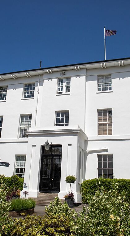 Sidcot School's white main building from the front in the sunshine