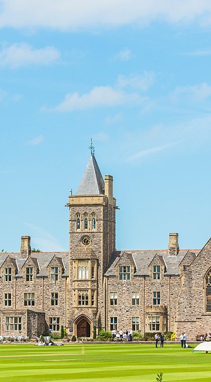 The impressive old buildings of Taunton School from the front with an extensive green pitch in front of its doors