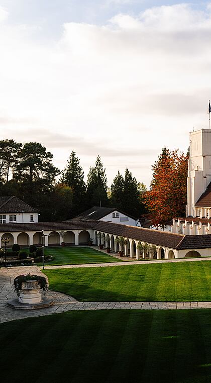 Wide-angle view of a school campus with brick buildings, lawns and a central pathway.