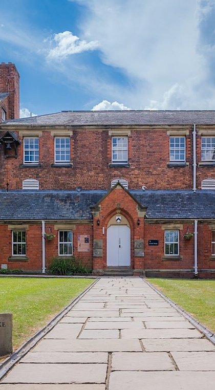 Red-brick school house next to grey-brick school chapel