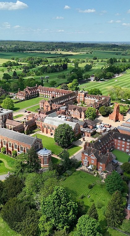 Aerial shot of huge school campus with fancy buildings and green sports fields