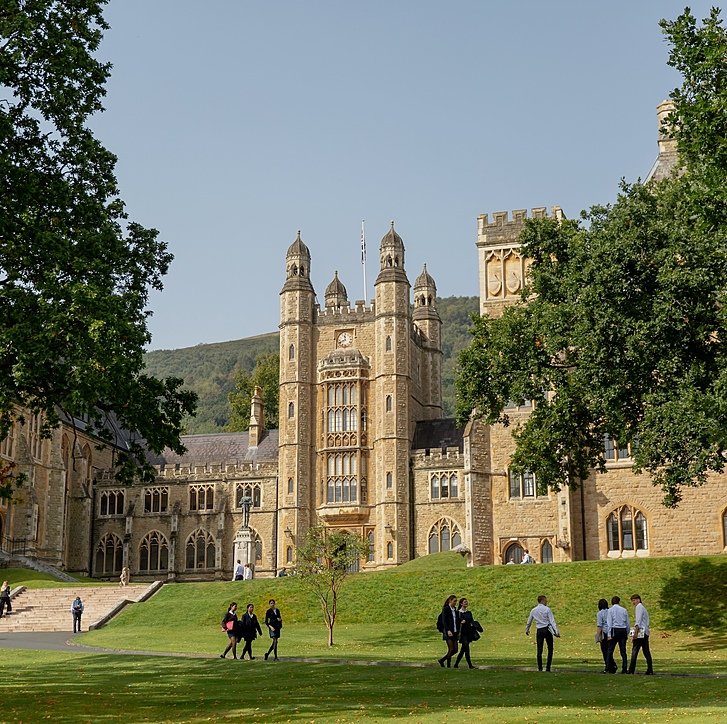 The stunning campus of Malvern College with pupils walking in front in the afternoon