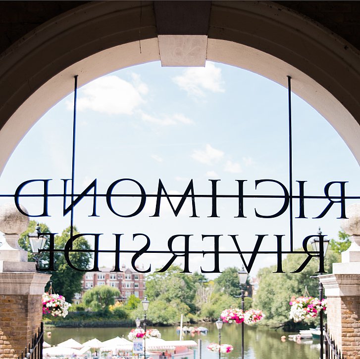 Backward sign of 'Richmond Riverside' with view onto the Thames river