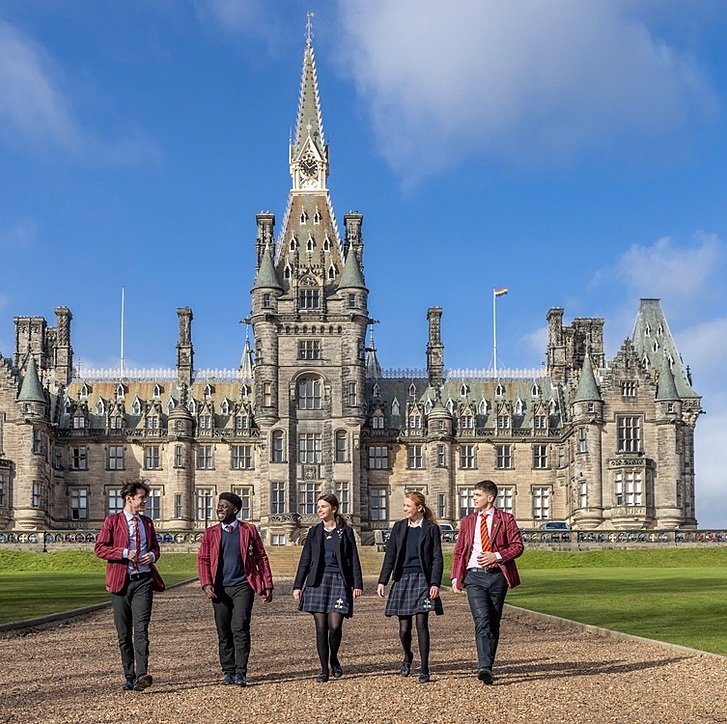 Five students walking in front of the main Fettes College building