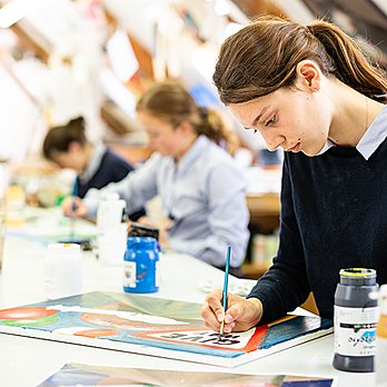 Students doing paintings in their school's bright art department