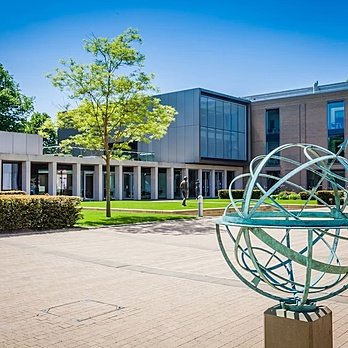 A sun clock infront of modern school buildings