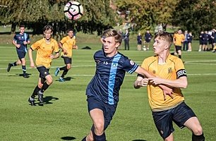 two footballer in blue and yellow fight for the ball