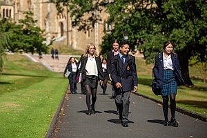 Malvern Pupils in their uniforms walking together over the school campus chatting