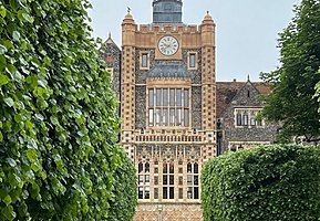 Beautiful clock tower with trees and well-maintained hedges left and right