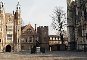 Courtyard with a statue at the center, surrounded by historic red-brick and stone school buildings.