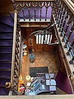 View from a balustrade down into a reception with stairs on the left
