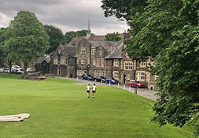 Two boys crossing the grass on their way to Sedbergh school